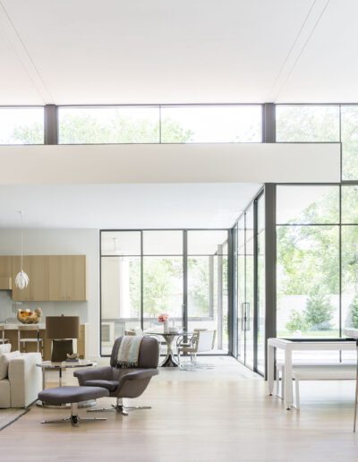 Modern open-plan living space with floor-to-ceiling windows and minimalist decor.